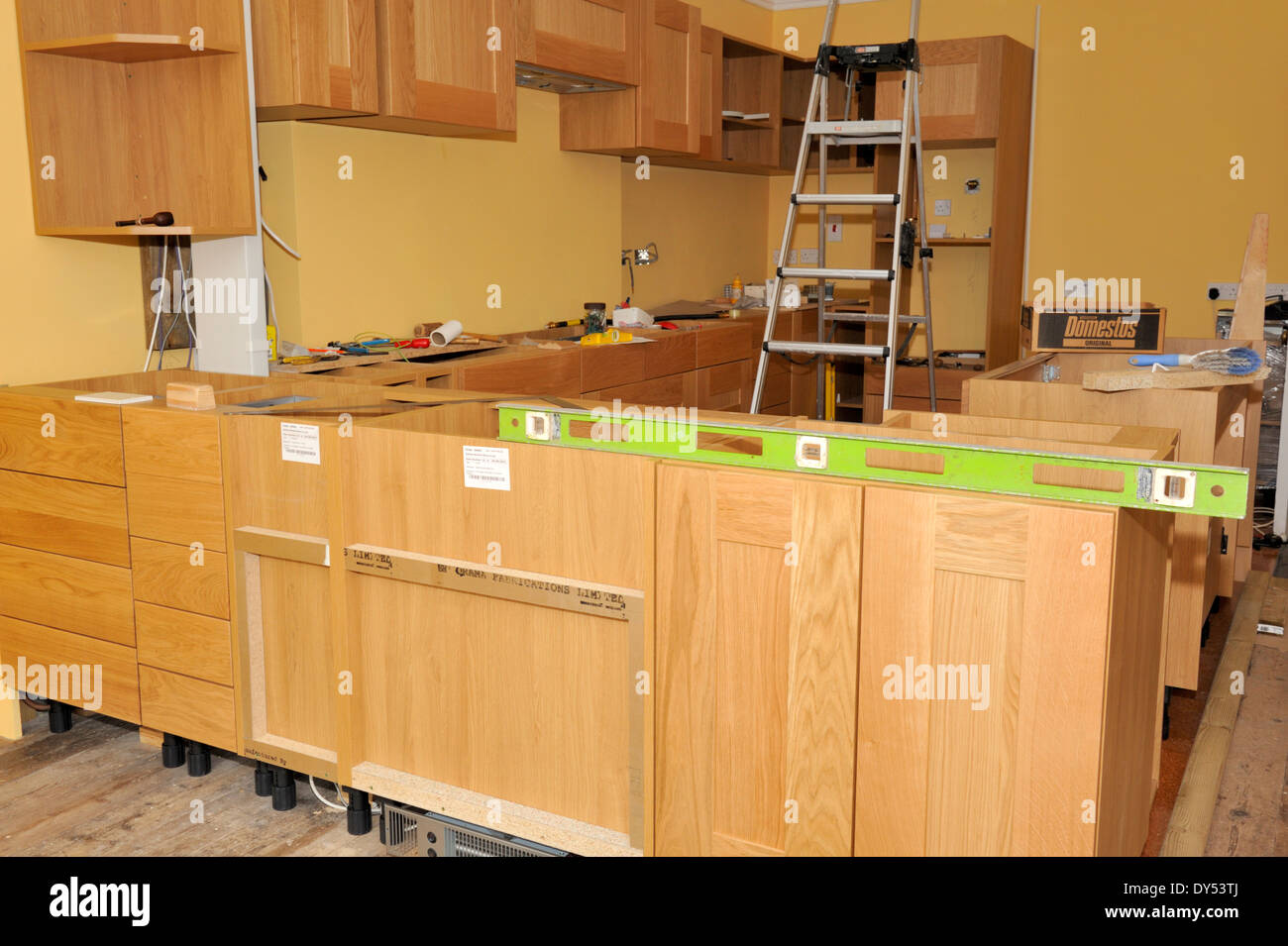 La costruzione di una cucina da pronto realizzato unità. Unità di livellamento durante l'installazione in modo che la linea in alto. Foto Stock