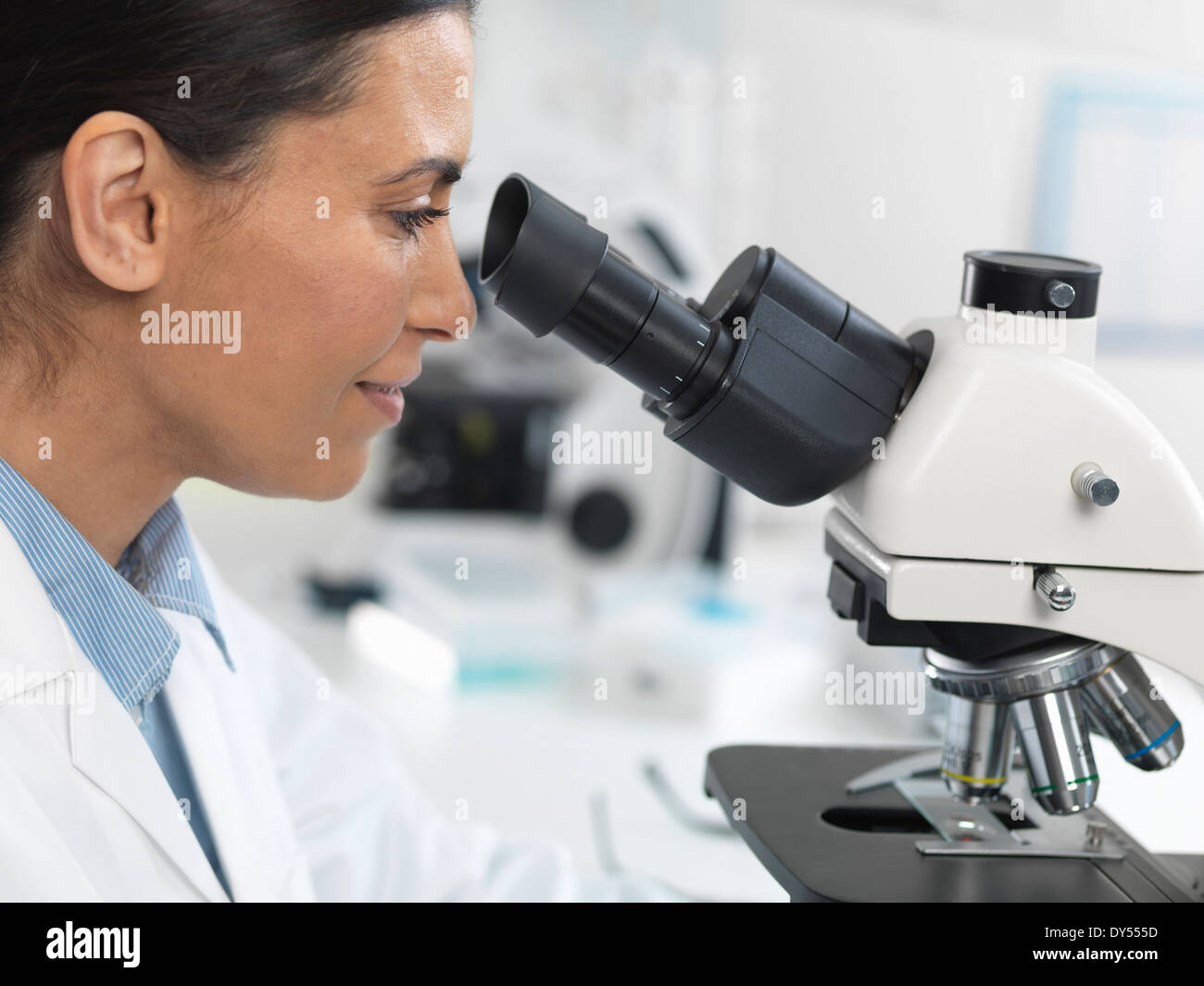 Donna scienziato visualizzazione diapositiva campione per il test clinico in laboratorio Foto Stock