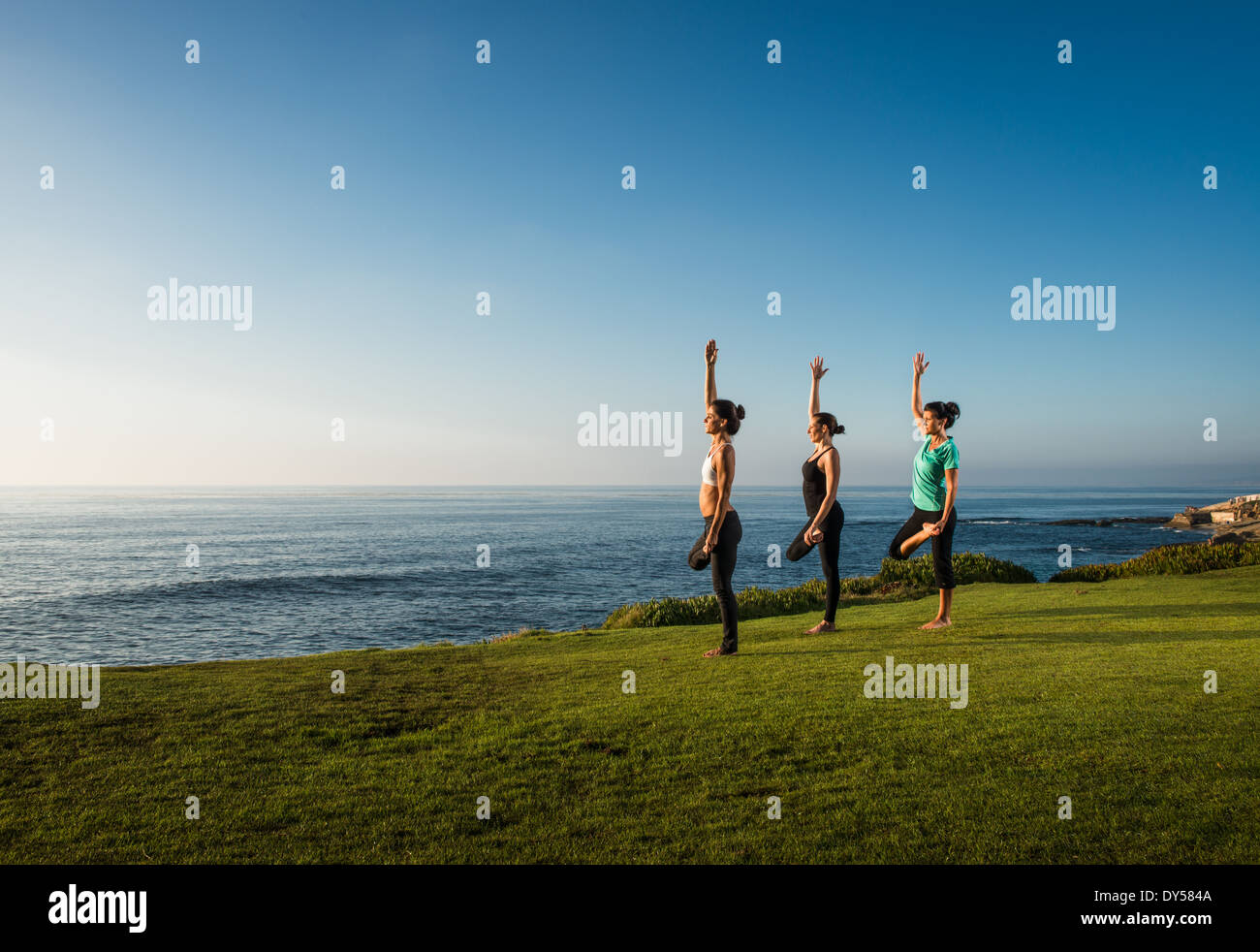 Le donne sulla scogliera, in posizioni di yoga Foto Stock