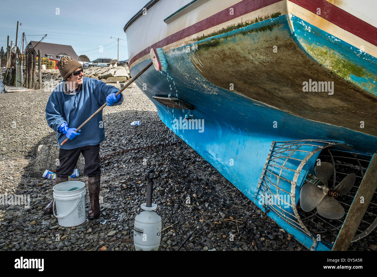 Pulizia di Primavera, Mark bianco un pescatore di aragoste in Kennebunkport Maine ,U.S.A.spende la pulizia giornaliera cirripedi al di fuori del lato inferiore della sua Lobster Boat,. È l'ultima cosa che ha a che fare per ottenere il suo astice vasi e iniziare la pesca(, la molla è davvero qui all ultimo credito: 2014 Foto di Richard F. Owens/ALAMY LIVE NEWS) Foto Stock