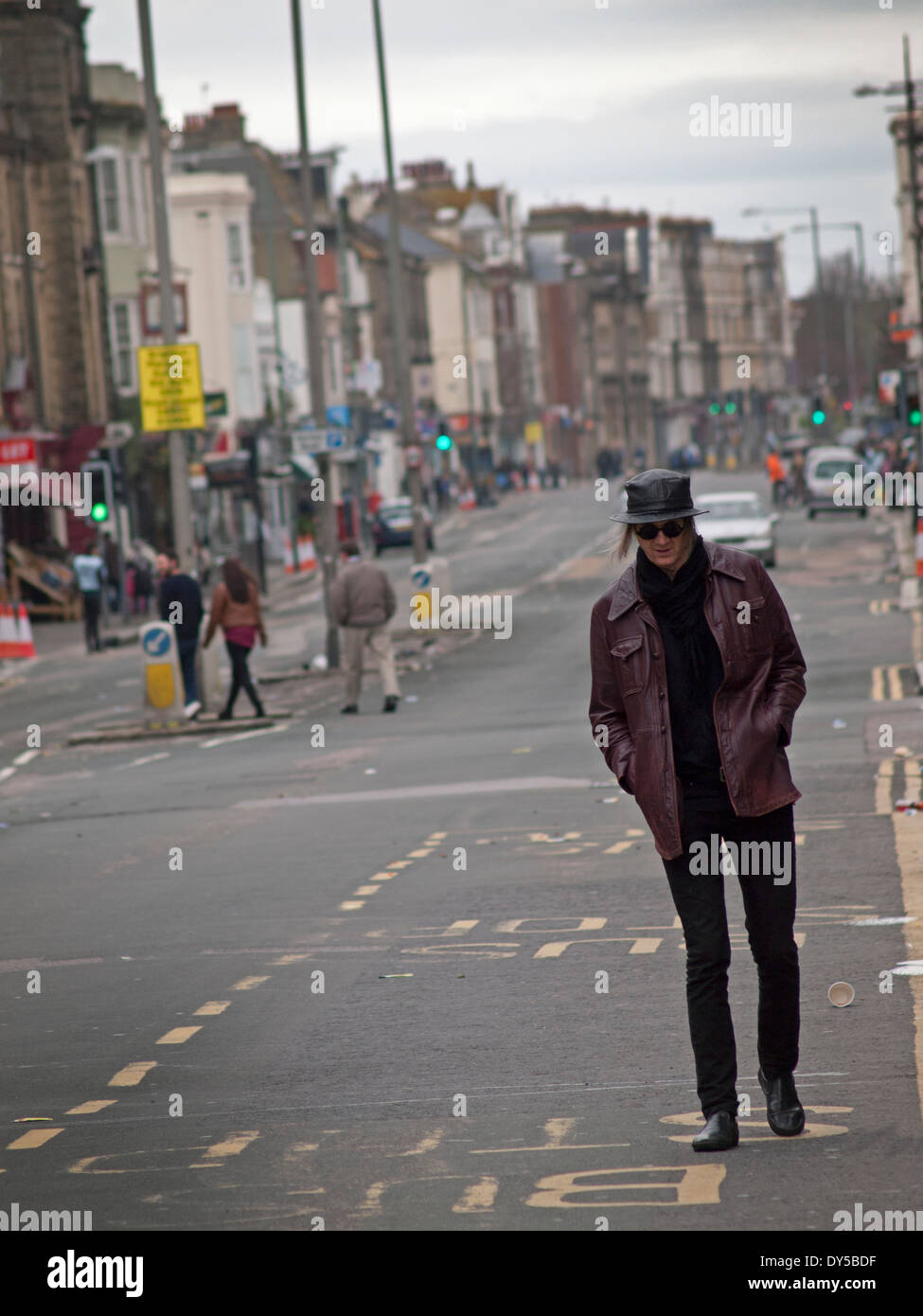 Un uomo cammina giù per una strada vuota a Hove, Brighton Foto Stock