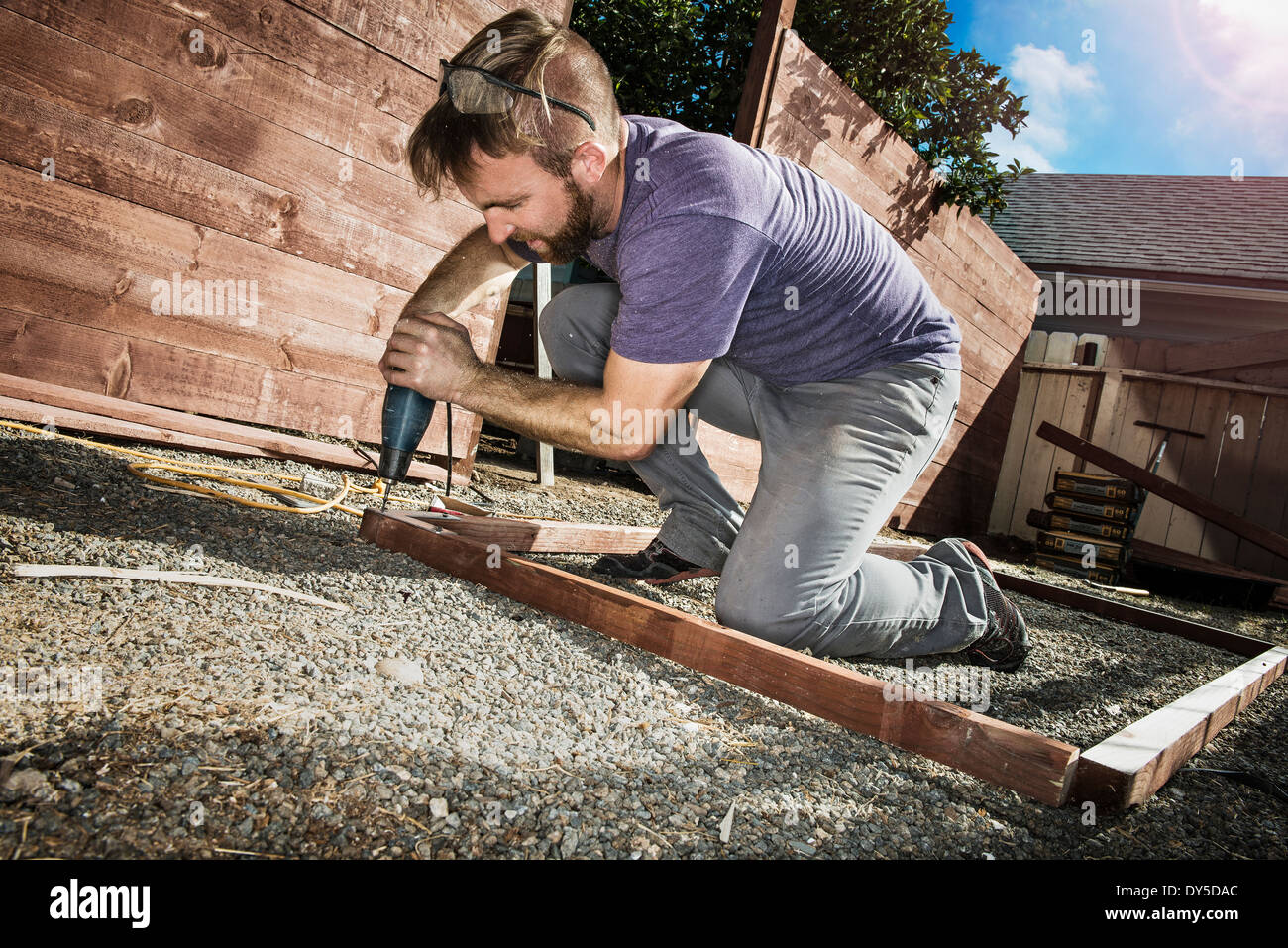 Joiner nel cortile posteriore foratura quadro di legno Foto Stock