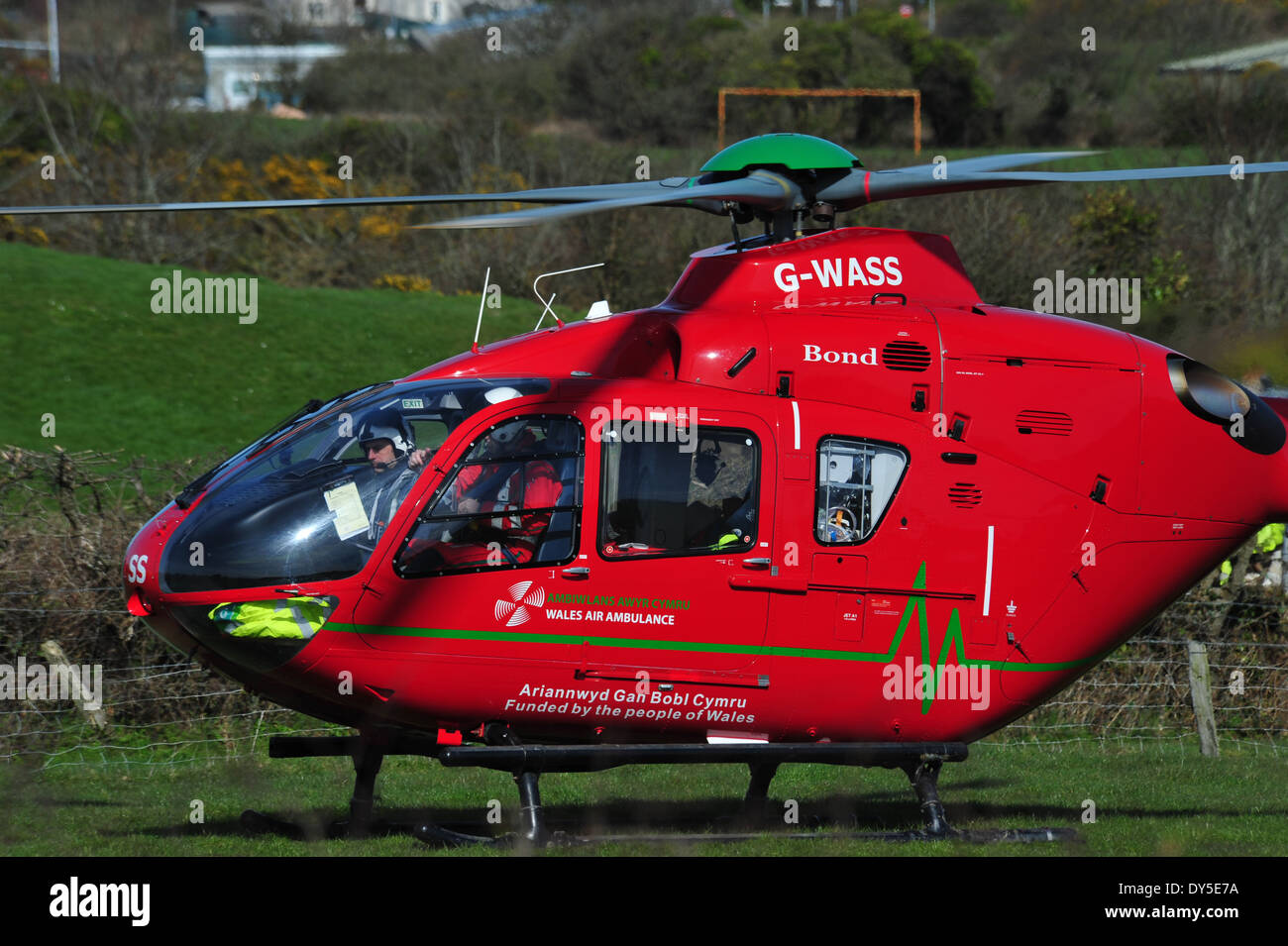 Il Galles Air Ambulance frequentando una RTA a Amlwch Anglesey North Wales UK battenti G-Wass welsh aereo elicottero Foto Stock