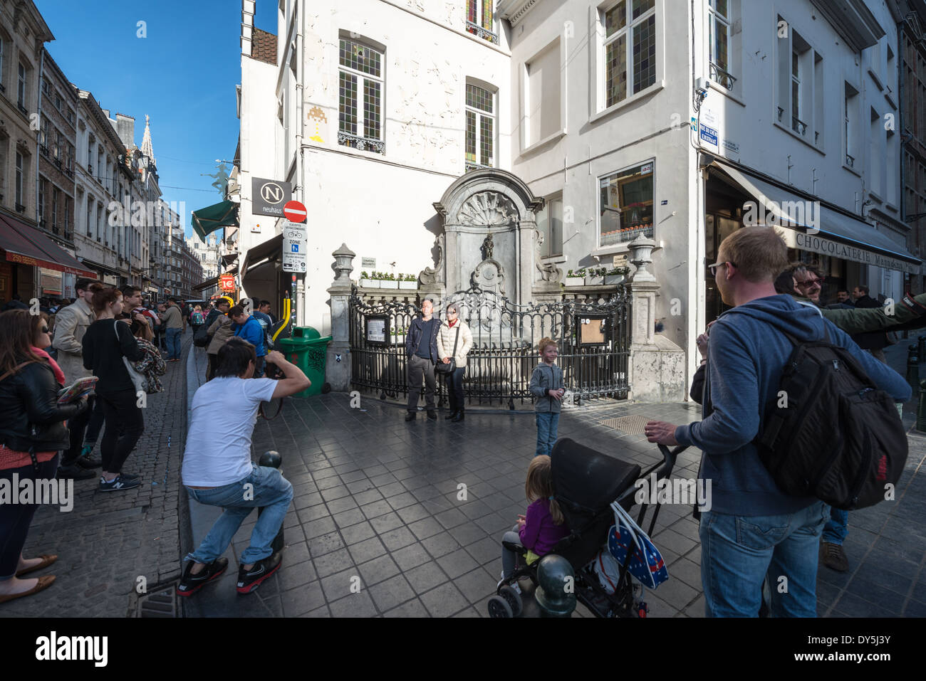 Fontana Manneken Pis turisti Bruxelles Belgio // BRUXELLES, Belgio — i turisti posano per le fotografie con la famosa fontana Manneken Pis all'angolo di Rue de l'Étuve/Stoofstraat. L'iconica statua in bronzo, una replica dell'originale di Hiëronymus Duquesnoy il Vecchio del 1619, rimane una delle località turistiche più popolari di Bruxelles per la fotografia. I visitatori si riuniscono in questo angolo storico per catturare immagini con la stravagante fontana che è diventata un simbolo del patrimonio culturale di Bruxelles. Foto Stock