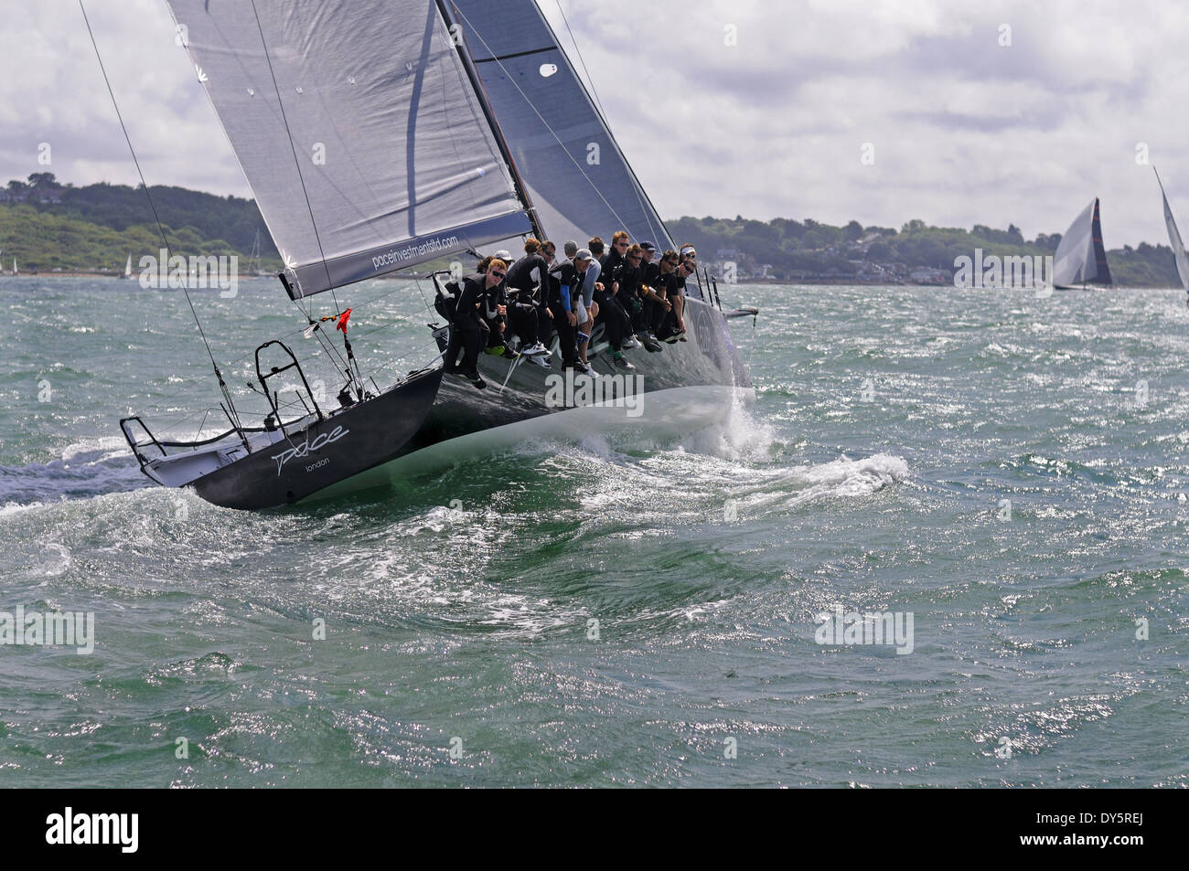 Ocean racing yacht facendo una drammatica svolta nel Solent con tutti i membri dell'equipaggio appoggiata fuori il lato di dritta Foto Stock