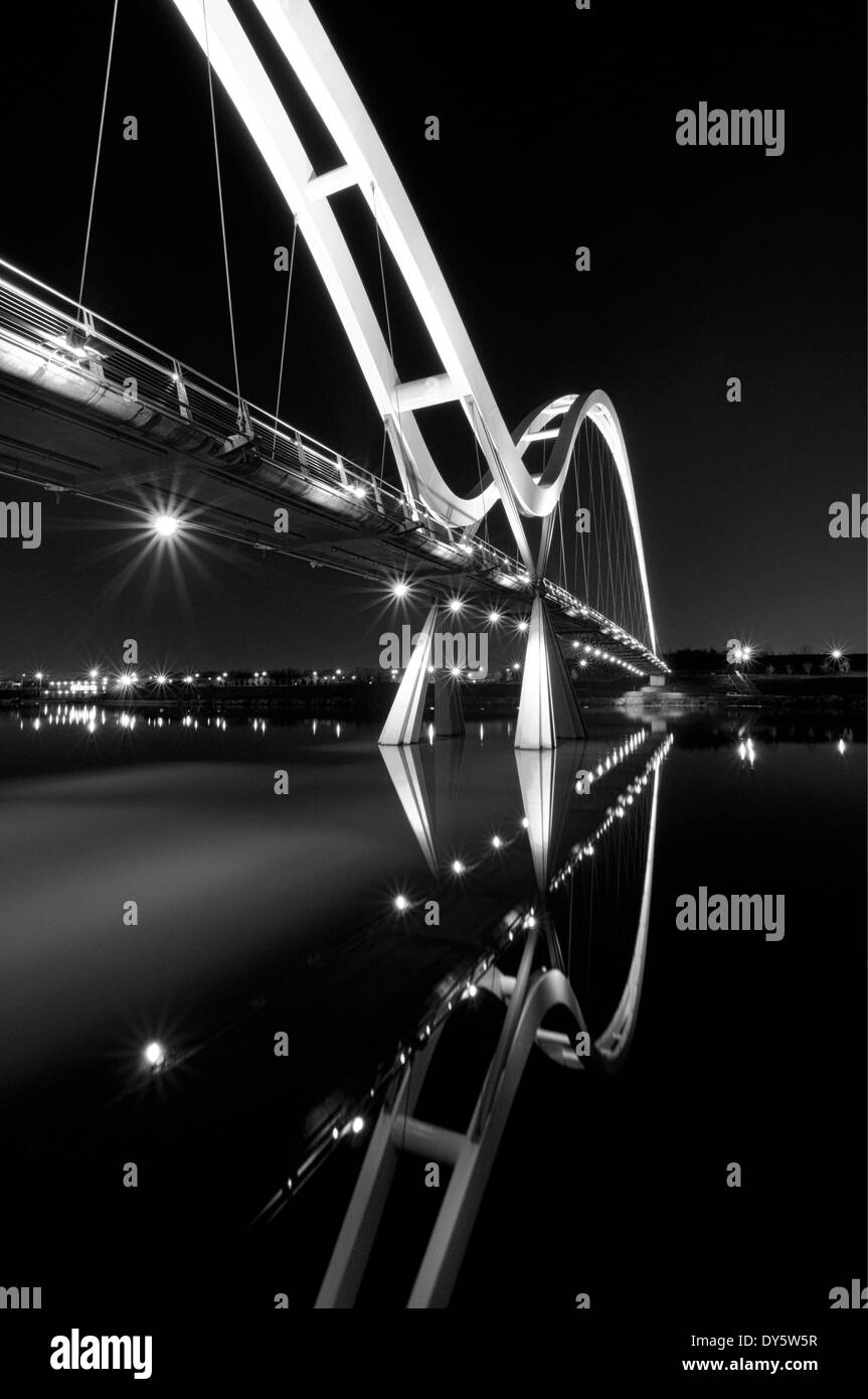 Infinito ponte sopra il Fiume Tees con la riflessione di notte tutto illuminato Foto Stock