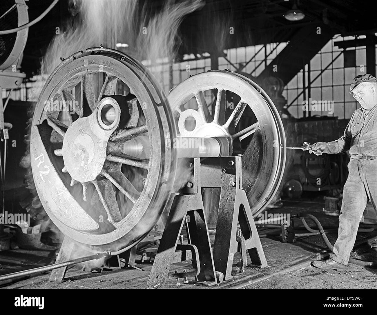 Un macchinista della Texas & Pacific Railway Company controlla la temperatura di una ruota locomotiva. Questa attività fa parte della manutenzione ordinaria per garantire operazioni ferroviarie sicure ed efficienti. Foto Stock