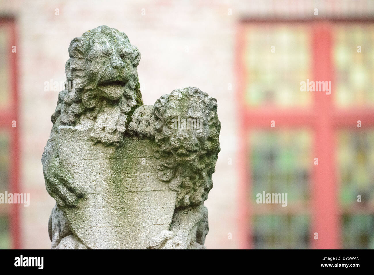 Leoni araldici intagliare la pietra Bruges Belgio // BRUGES, Belgio — Una coppia di leoni araldici in pietra che reggono uno scudo si erge come elementi architettonici decorativi nel centro storico di Bruges. Queste figure scultoree rappresentano il tradizionale simbolismo civico comune nelle città medievali europee. I leoni dimostrano le sofisticate tradizioni di intaglio della pietra che hanno contribuito al patrimonio architettonico di Bruges. Foto Stock