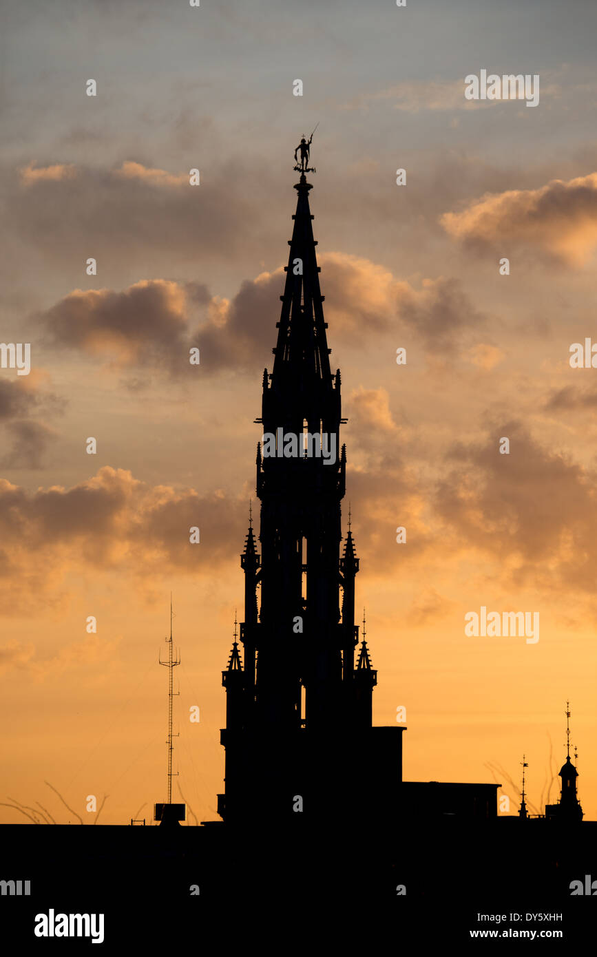 BRUXELLES, Belgio — la sagoma dello skyline di Bruxelles al tramonto contro un cielo dorato con poche nuvole. L'alta guglia è la torre del Municipio di Bruxelles (Hotel de Ville) che si trova a 96 metri. Foto Stock