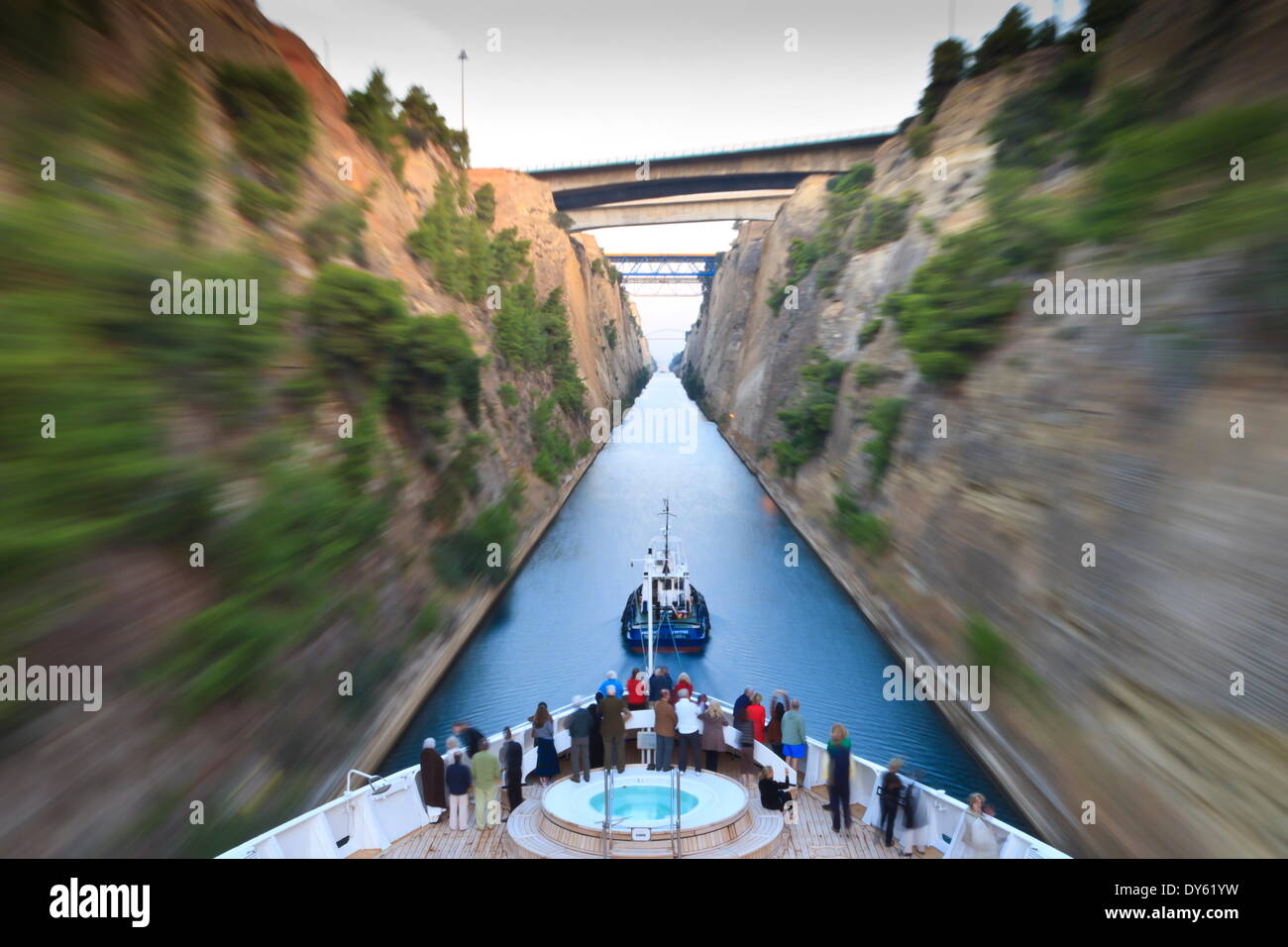 I turisti sulla prua di una piccola nave da crociera trainato da un rimorchiatore, la mattina presto il transito del Canale di Corinto, Grecia, Europa Foto Stock