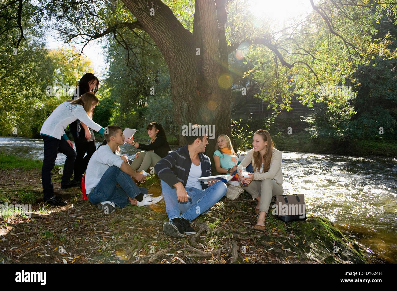 Un gruppo di giovani apprendendo a Dreisam riverbank, Freiburg im Breisgau, Foresta Nera, Baden-Württemberg, Germania Foto Stock
