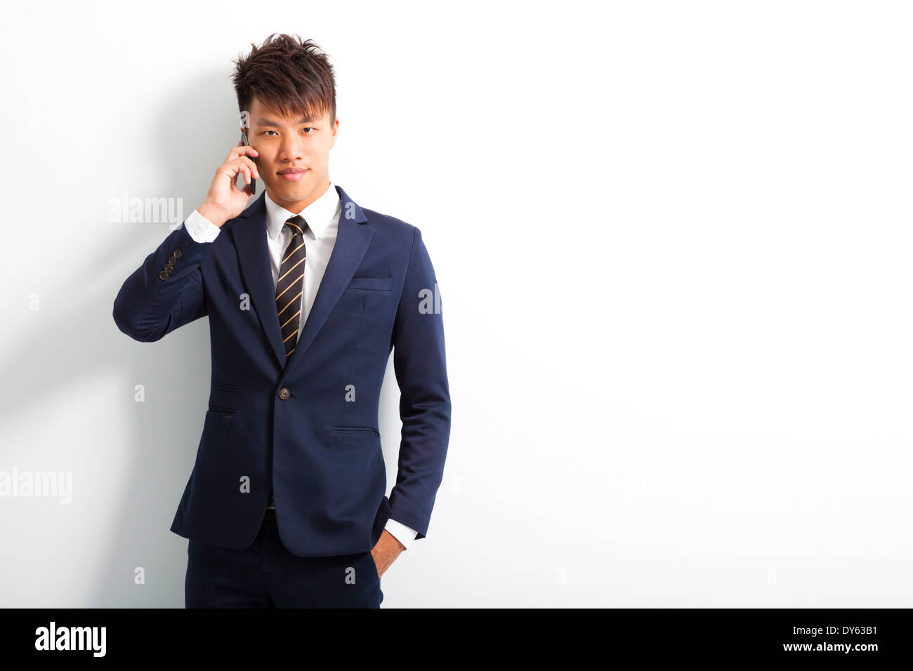 Sorridente giovane uomo utilizza lo smartphone per conversazione Foto Stock