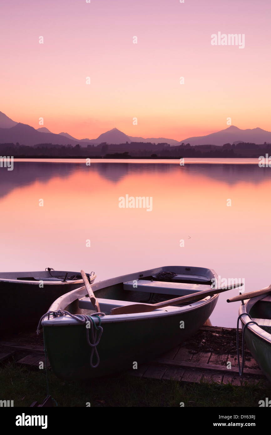 Barche a remi sul Lago Hopfensee al tramonto, vicino a Fussen, Allgau, Allgau Alpi, Baviera, Germania, Europa Foto Stock