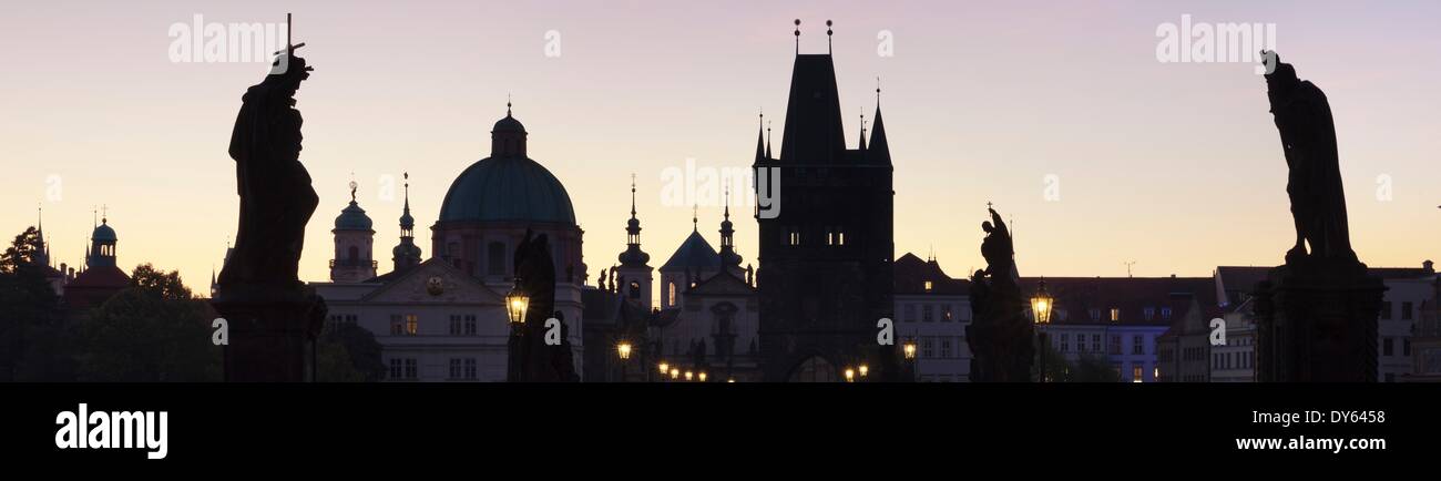 Silhouette di statue sul Ponte Carlo, sito UNESCO, Cupola della chiesa di San Francesco e la vecchia città ponte, Praga, Repubblica Ceca Foto Stock