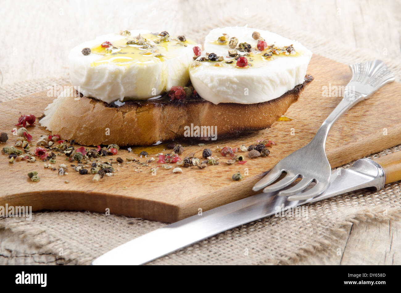 Mozzarella di bufala con pepe macinato sul forno pane tostato Foto Stock