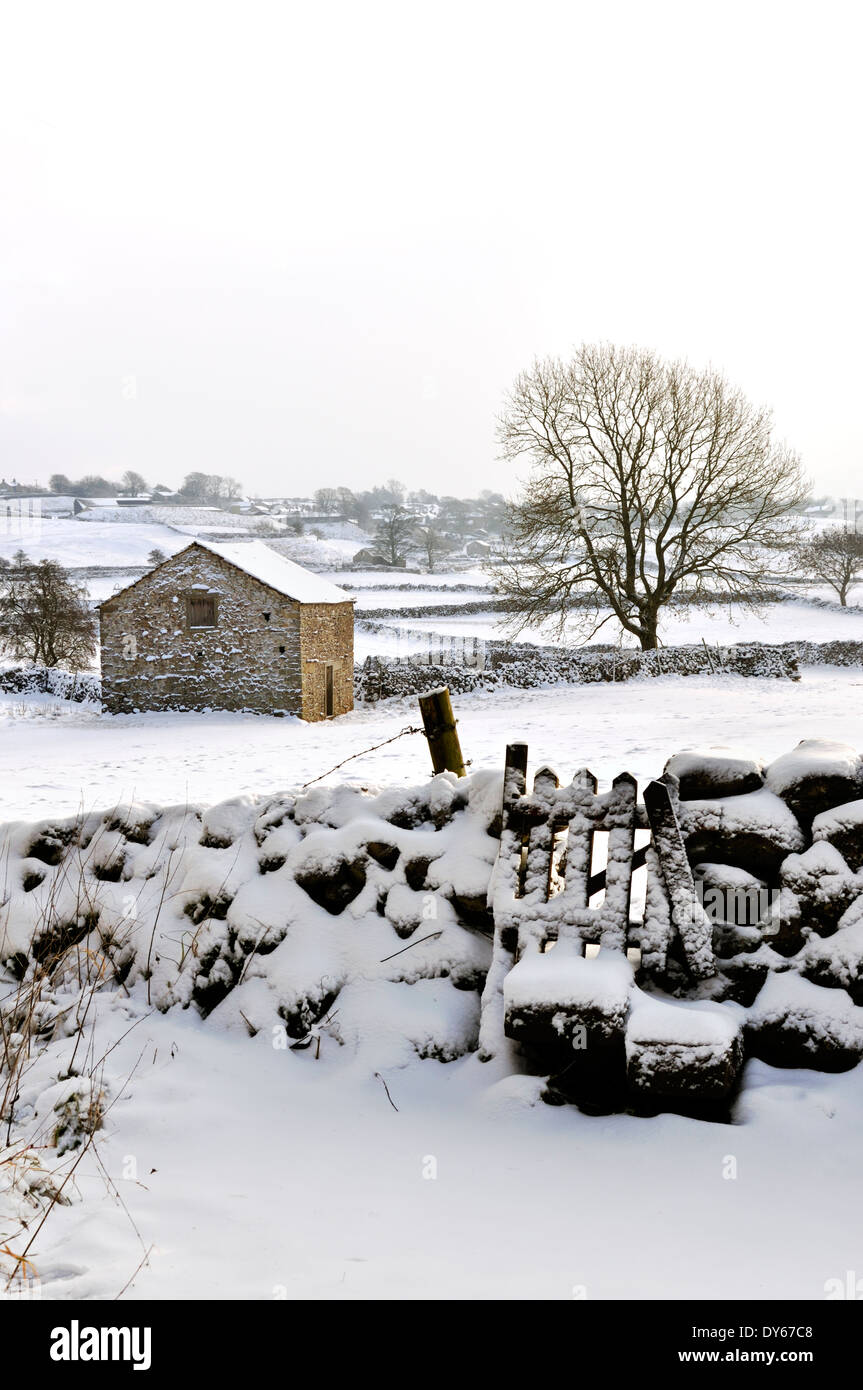Snowscene con stile ed un fienile in Yorkshire Dales Foto Stock