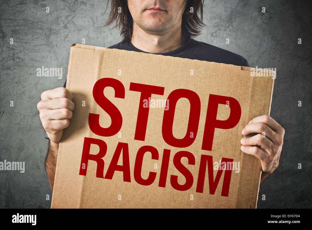 Uomo con banner di cartone con STOP razzismo messaggio Foto Stock