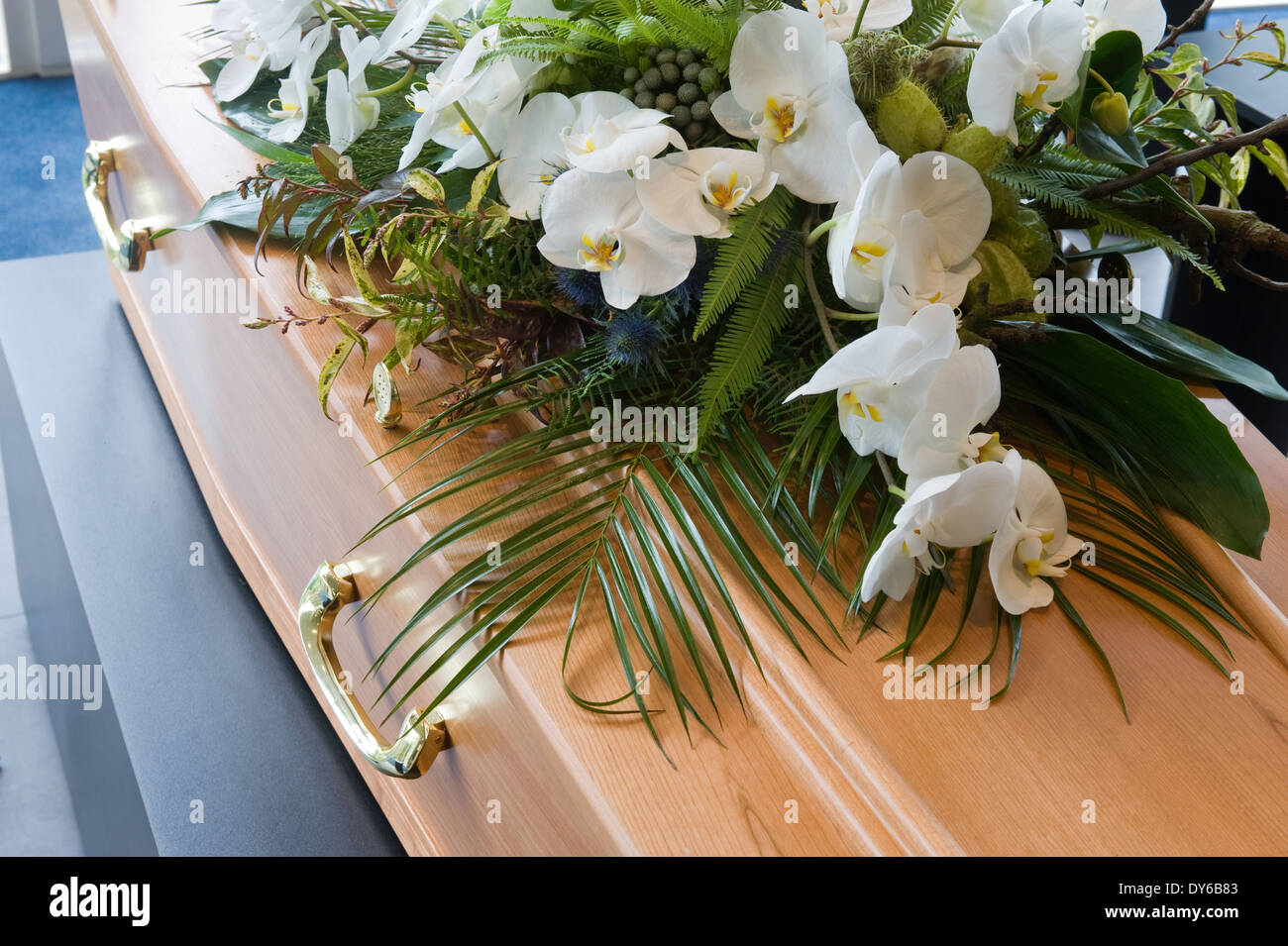 Una bara con un omaggio floreale in un obitorio Foto Stock