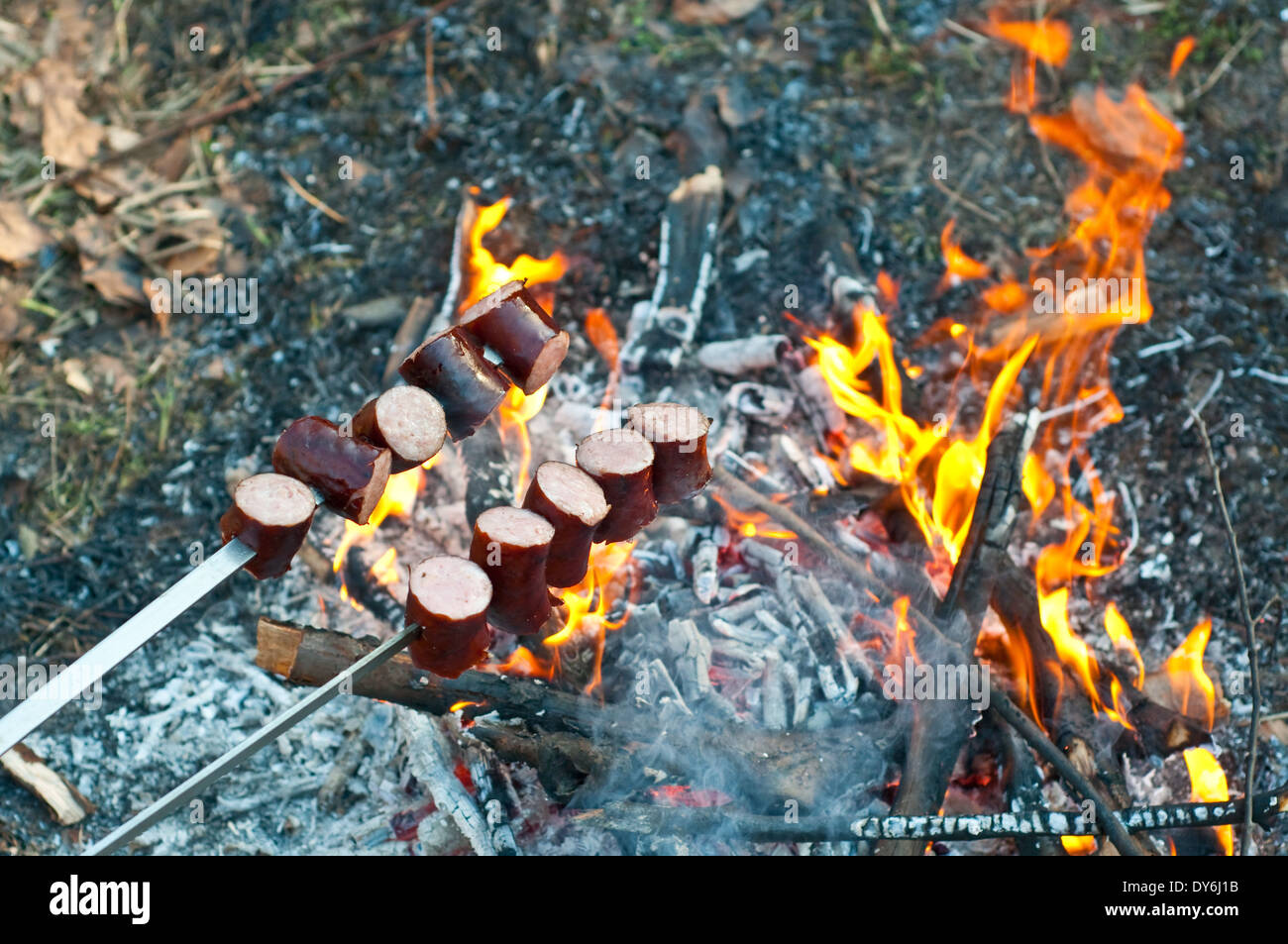 Salsicce alla griglia al di sopra del fuoco Foto Stock