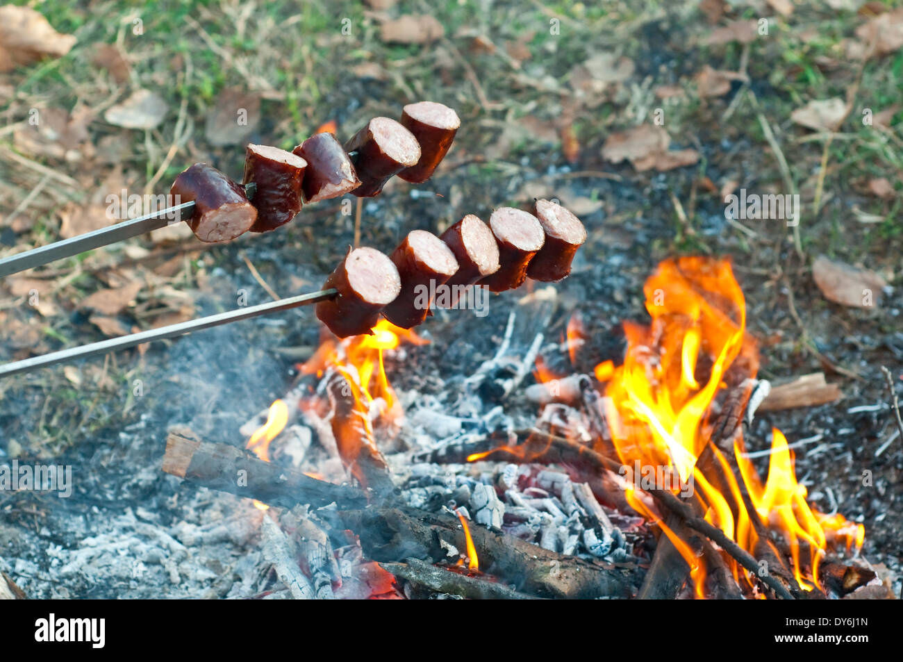 Salsicce alla griglia al di sopra del fuoco Foto Stock