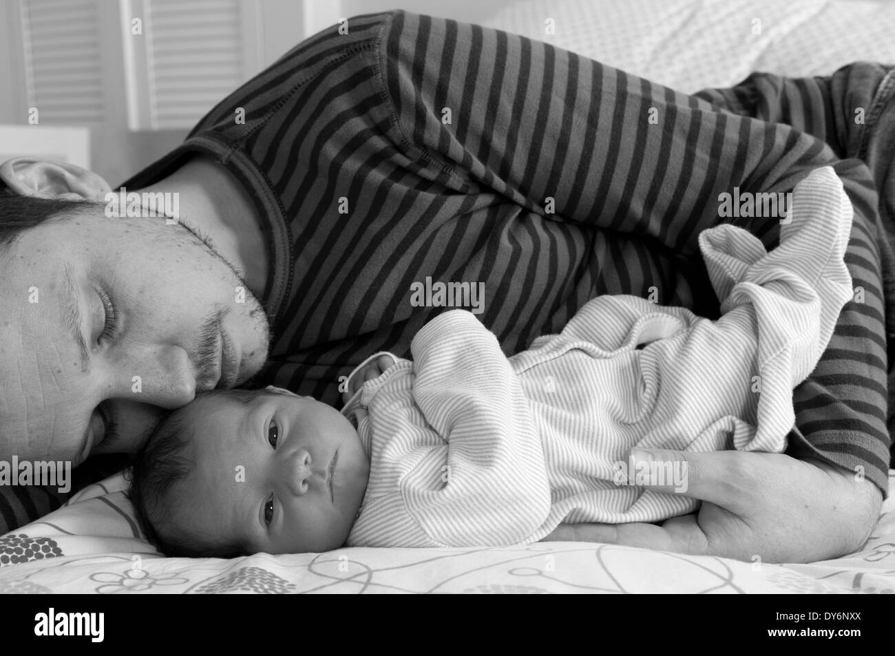 Immagine in bianco e nero del padre sdraiato con la sua bambina neonato coccolante Foto Stock