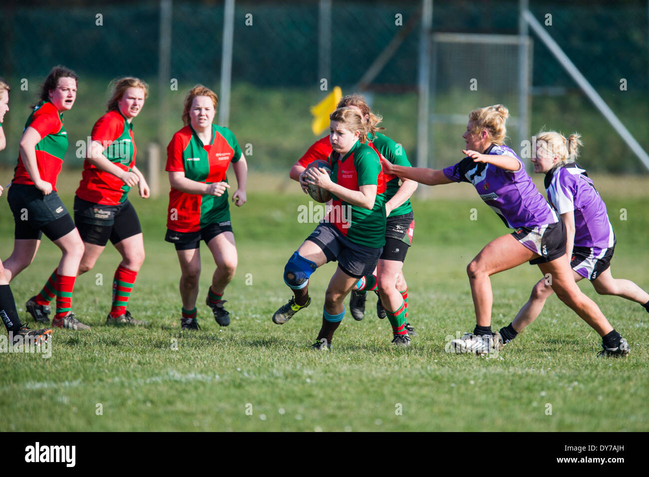 Aberystwyth university donne (in rosso e verde) giocando a rugby contro il Trinity St Davids university, Wales UK Foto Stock