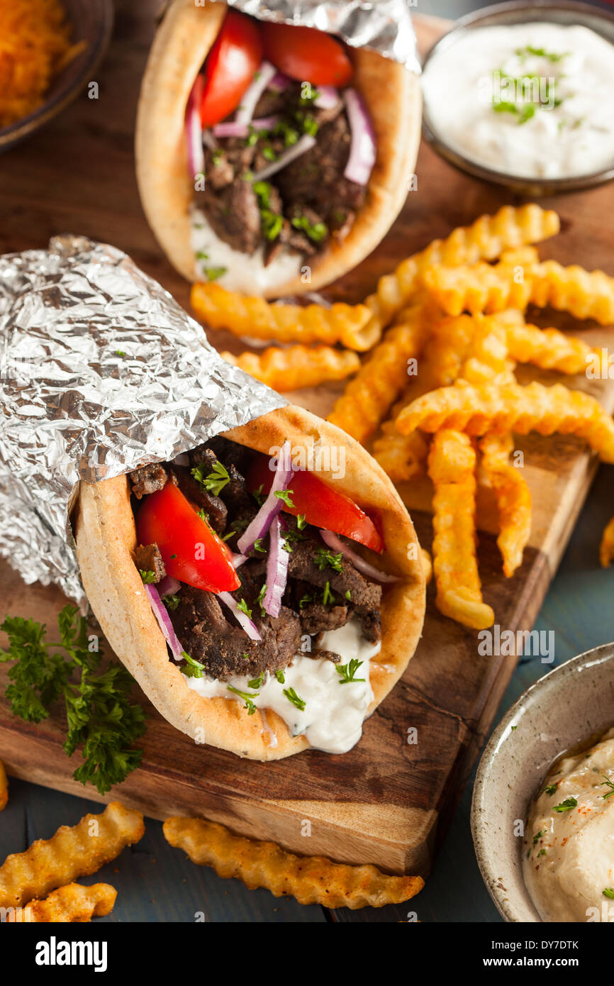 In casa il giroscopio di carne con salsa tzatziki, pomodori e patate fritte Foto Stock