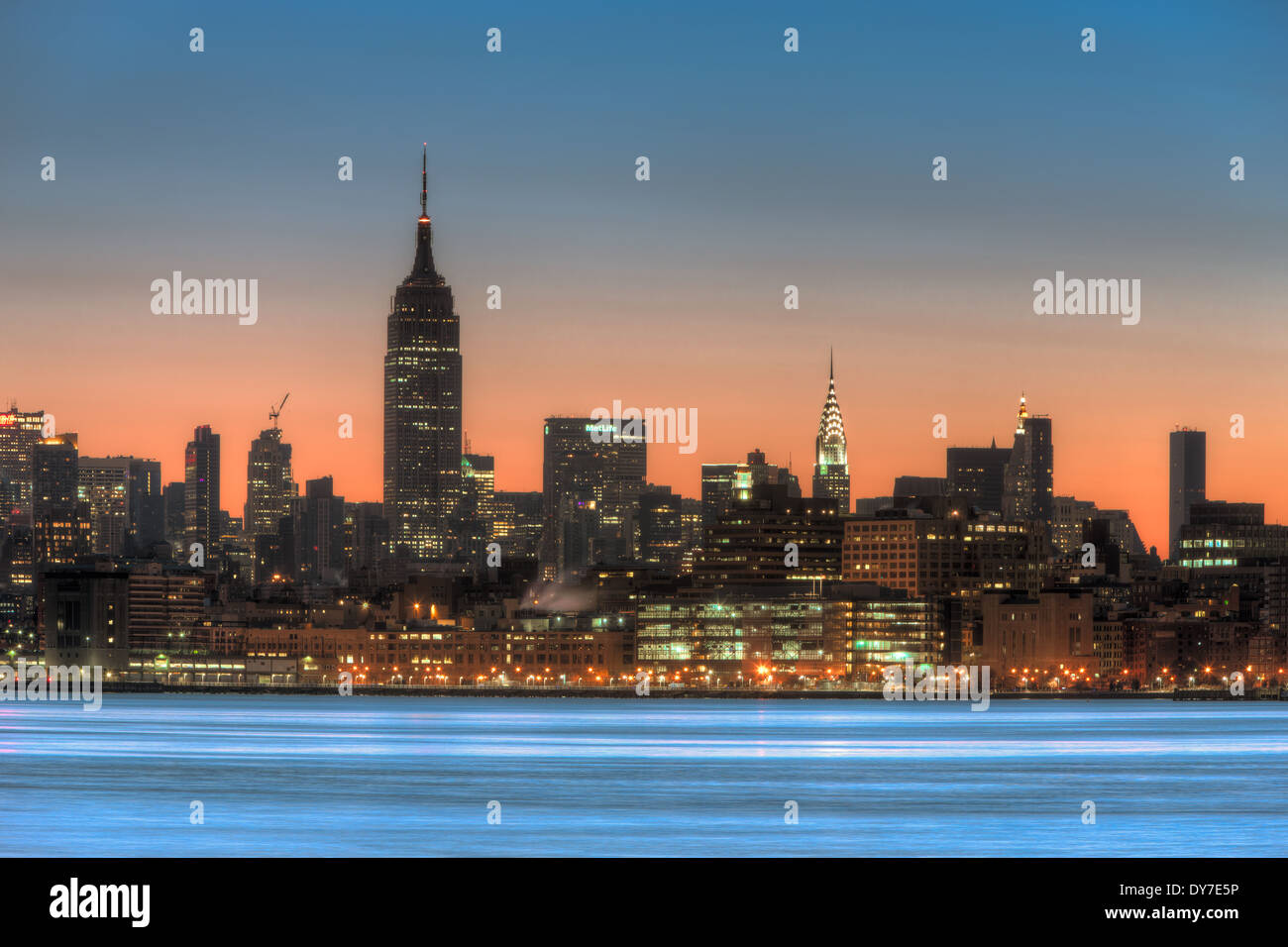 Il cielo arancione comincia a schiarire oltre l'Empire State Building e il mid-town skyline di Manhattan a New York City. Foto Stock