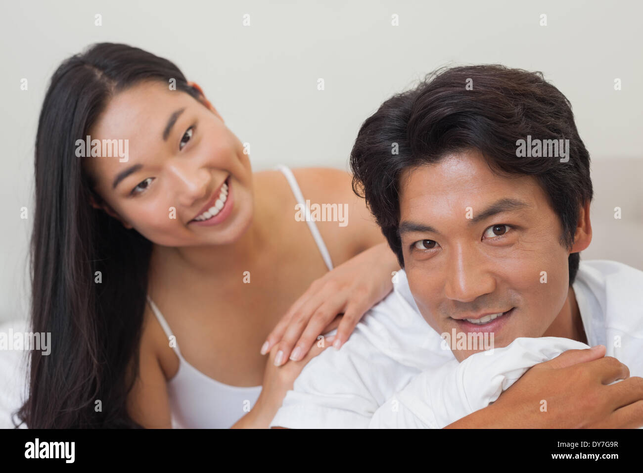 Coppia felice giacente sul letto insieme Foto Stock
