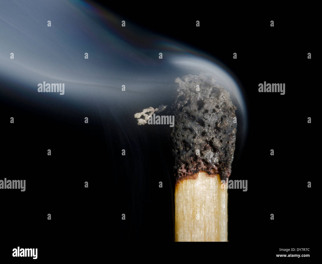 Un bruciata match dopo essere stato bruciato, mostrando il fumo che emana da essa, su uno sfondo nero. Bruciò testa match. Foto Stock