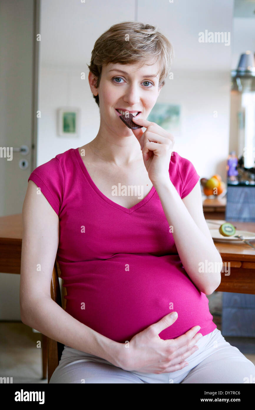 Donna incinta di mangiare Foto Stock