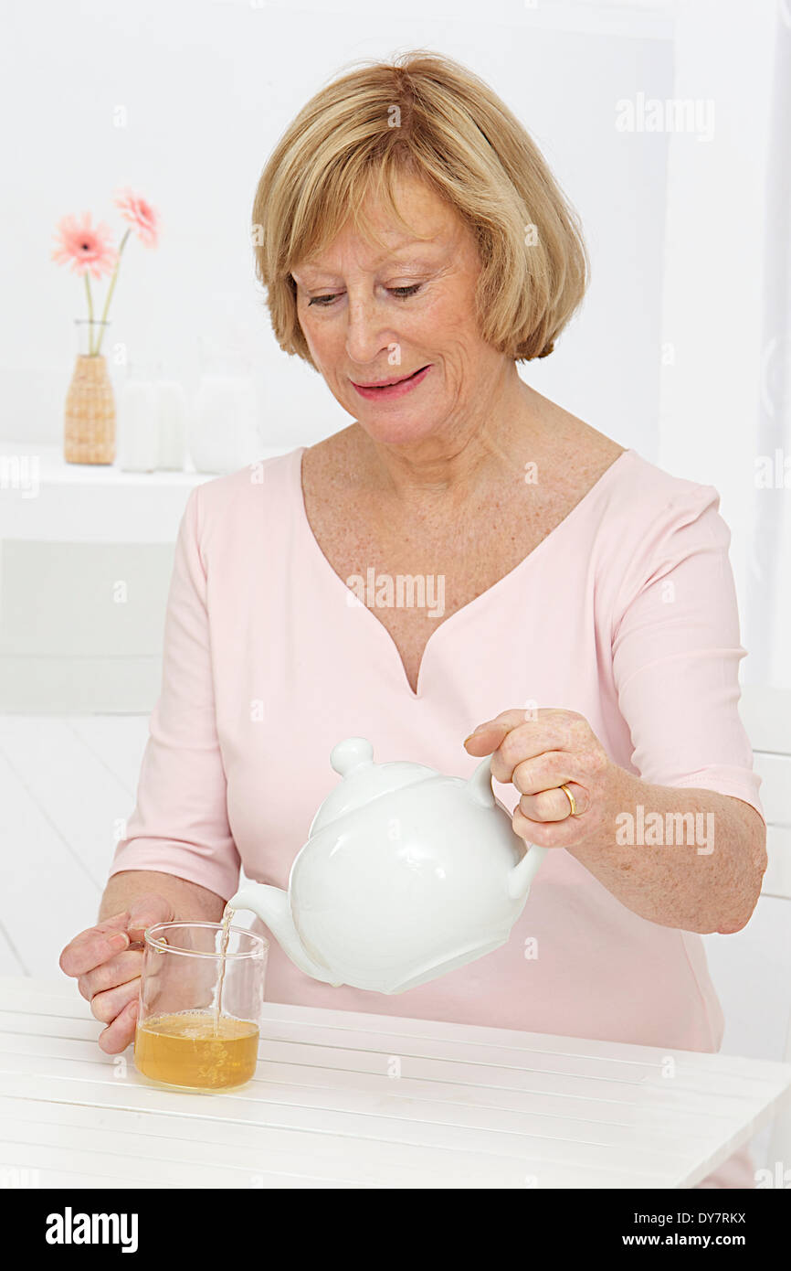 Persona anziana con bevanda calda Foto Stock