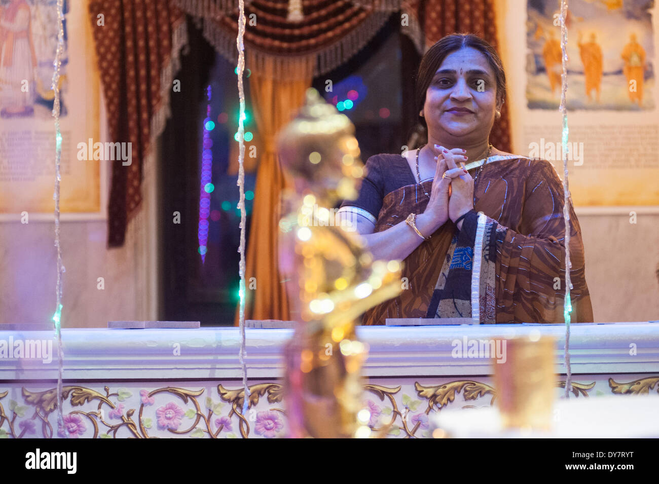 Londra, Regno Unito. 8 Aprile, 2014. Una donna Indù in abito tradizionale adora e prega davanti alla statua di Bhagwan Swaminarayan durante le celebrazioni di Swaminarayan Jayanti a Neasden temple di Londra, per contrassegnare la manifestazione sulla terra di Bhagwan Swaminarayan nel 1781. Credito: Piero Cruciatti/Alamy Live News Foto Stock