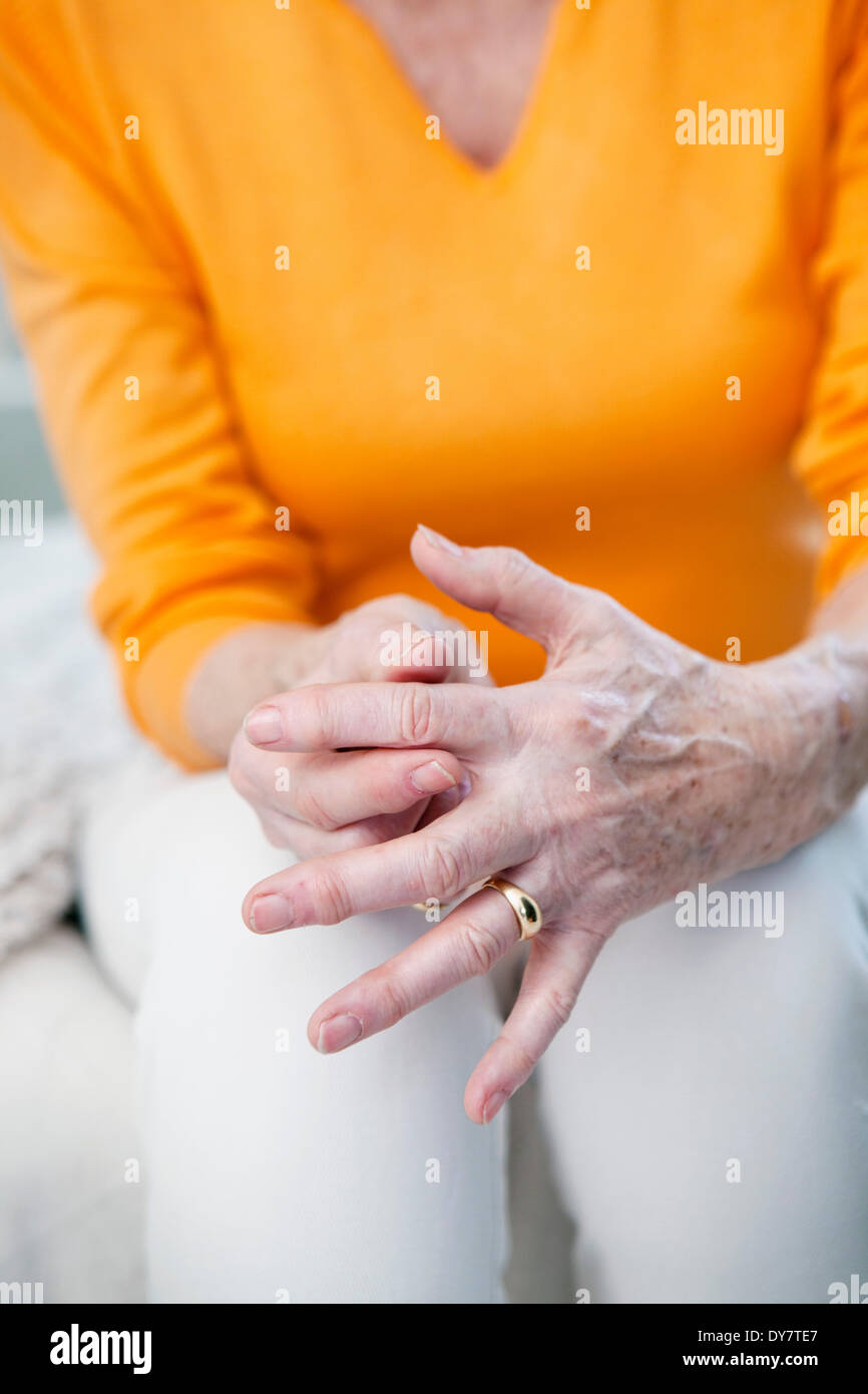 Persona anziana con mano dolorosa Foto Stock