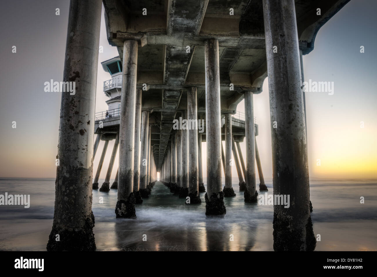 Una lunga esposizione cattura lenta onde in movimento sotto la Huntington Beah Pier in Huntington Beach, California Foto Stock