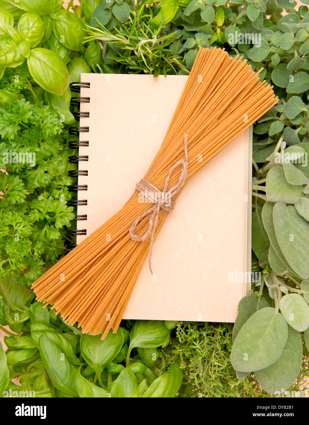 Recipebook con varietà di erbe fresche e mazzo di spaghetti Foto Stock