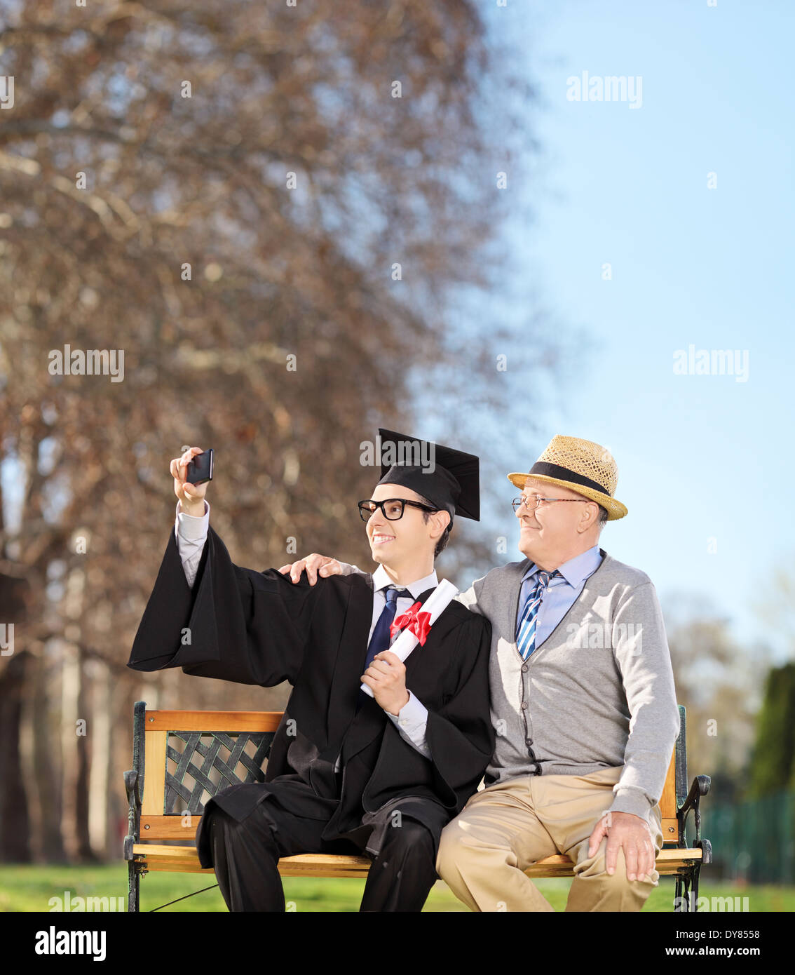 Studente maschio e il suo fiero padre selfie tenendo in posizione di parcheggio Foto Stock