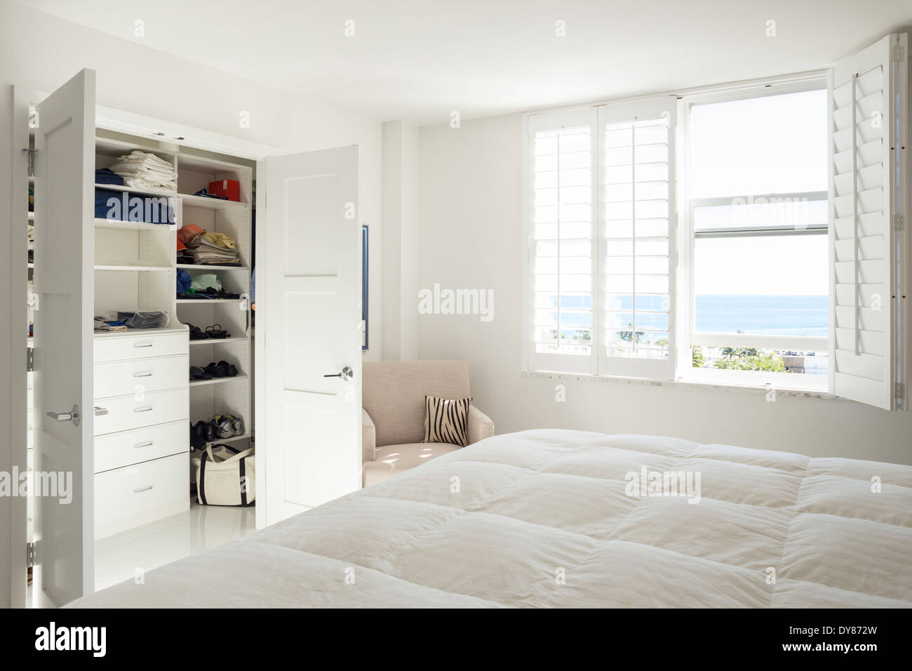 Tutto bianco soleggiate, luminose, mostrare la camera da letto matrimoniale con armadio a muro USA Foto Stock
