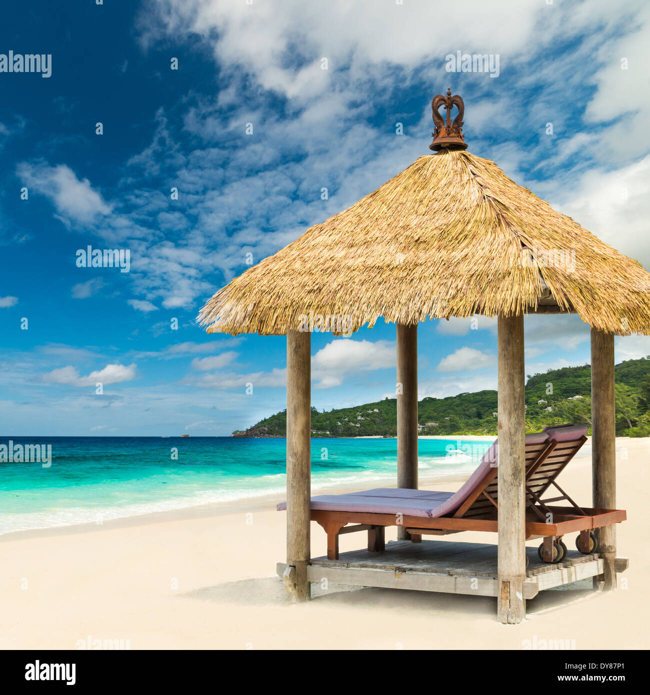 Lettini da spiaggia con tetto e mare turchese Foto Stock