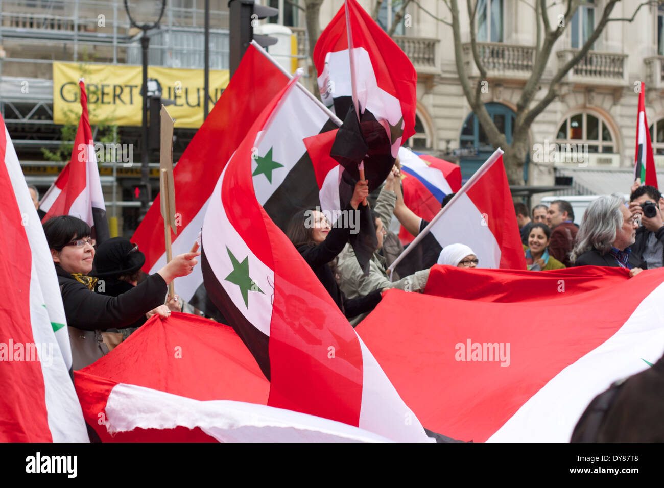 Pro Bashar sostenitori sventolando bandiere siriane nel centro di Parigi Foto Stock