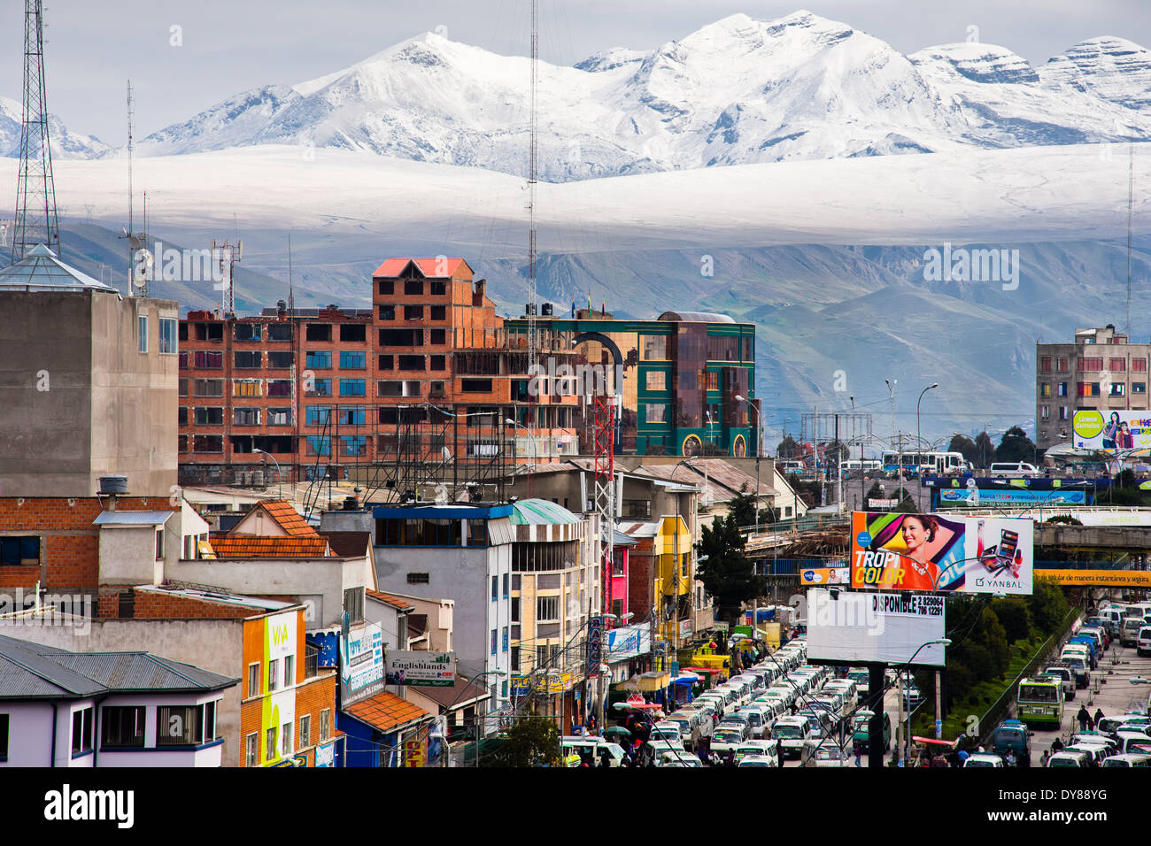 Cime coperte di neve delle Ande, con un traffico autostradale inceppamento in primo piano, sono visibili nella città di El Alto, Bolivia. Foto Stock