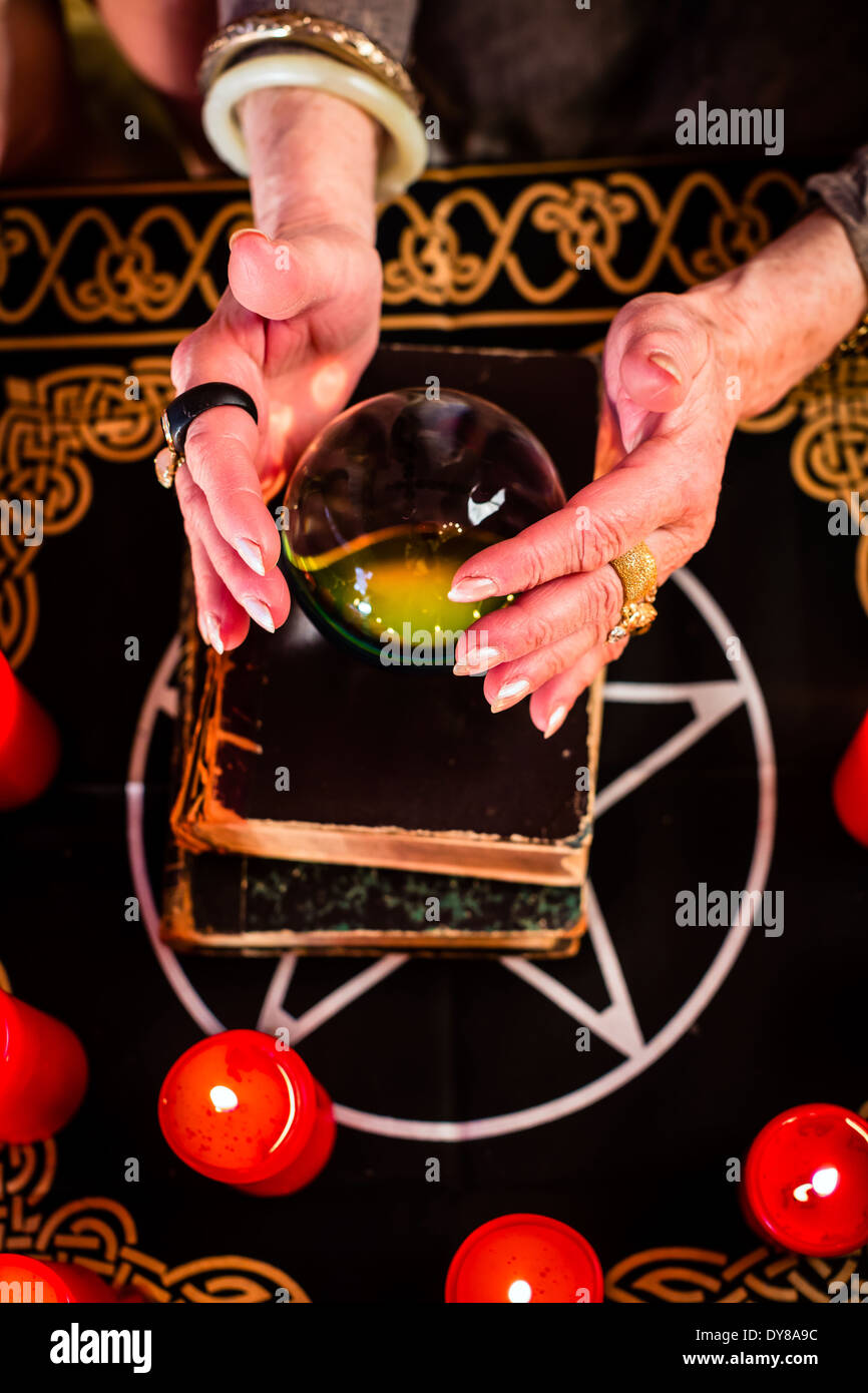 Fortuneteller femmina o Oracle esoteriche, vede nel futuro guardando nella loro sfera di cristallo durante una Seance Foto Stock