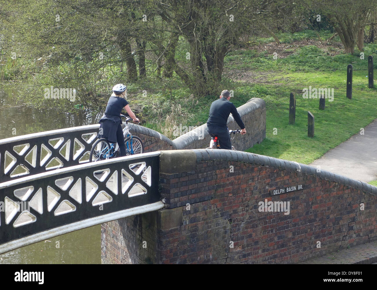 Coppia caucasica Escursioni in bicicletta su un ponte sul canale a Dudley No1 Canal, Brierley Hill, West Midlands, England, Regno Unito Foto Stock