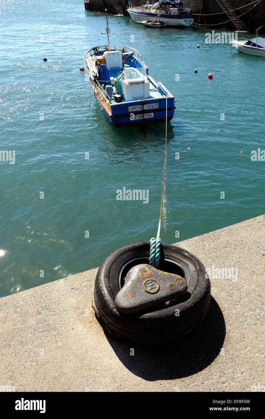 Calheta Madeira Portogallo. Una piccola barca da pesca ancorati nel porto con un pneumatico in gomma Foto Stock