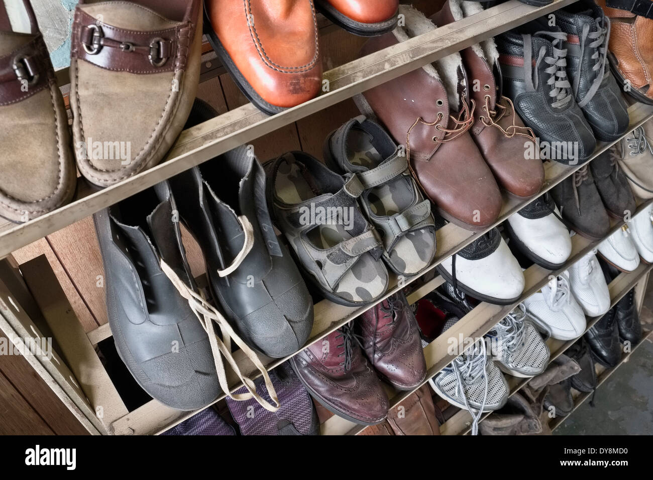 Vecchie scarpe su un vecchio rack in un vecchio shoe repair shop Foto Stock