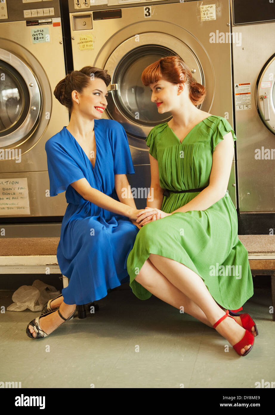 Giovani suore in stile retrò seduti insieme in servizio lavanderia Foto Stock