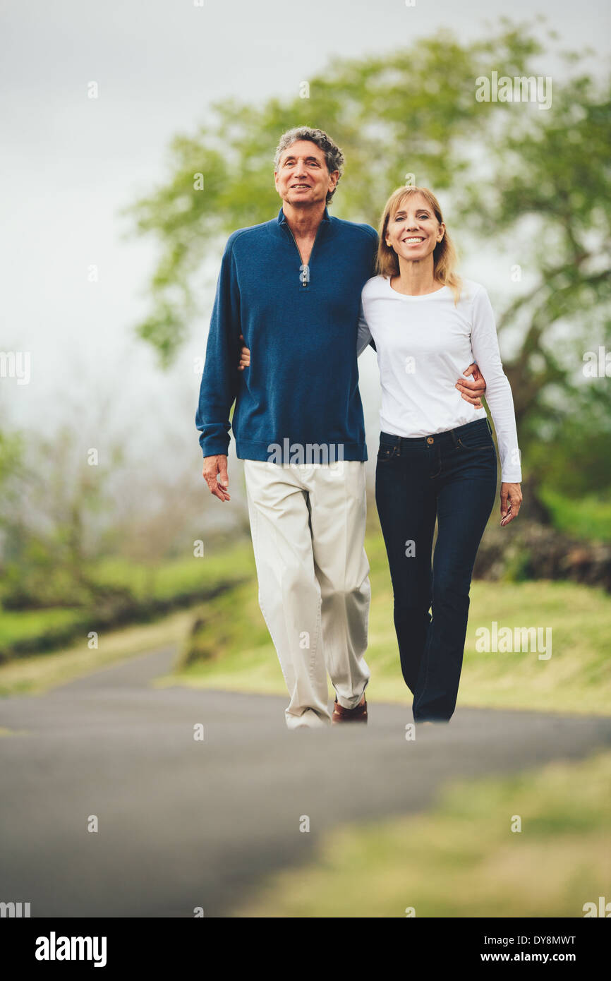 Felice amorevole coppia di mezza età camminando sulla bella strada di campagna Foto Stock