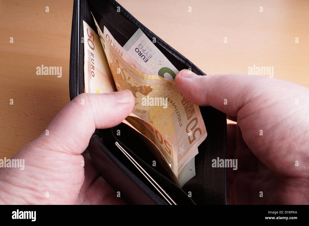 Mani maschio apertura portafoglio pieno di banconote in euro Foto Stock