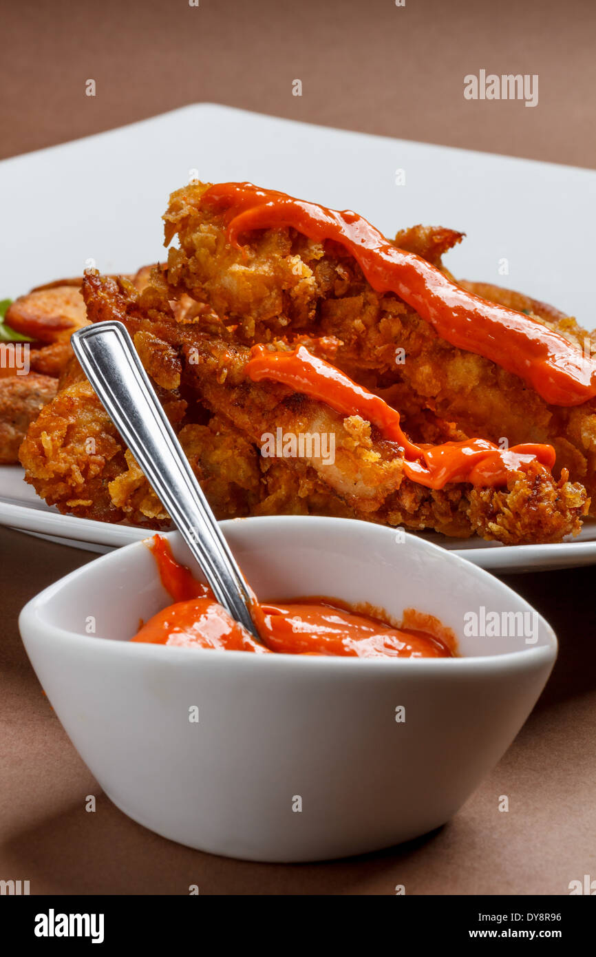 Croccanti bastoncini di pollo con salsa al peperoncino Foto Stock