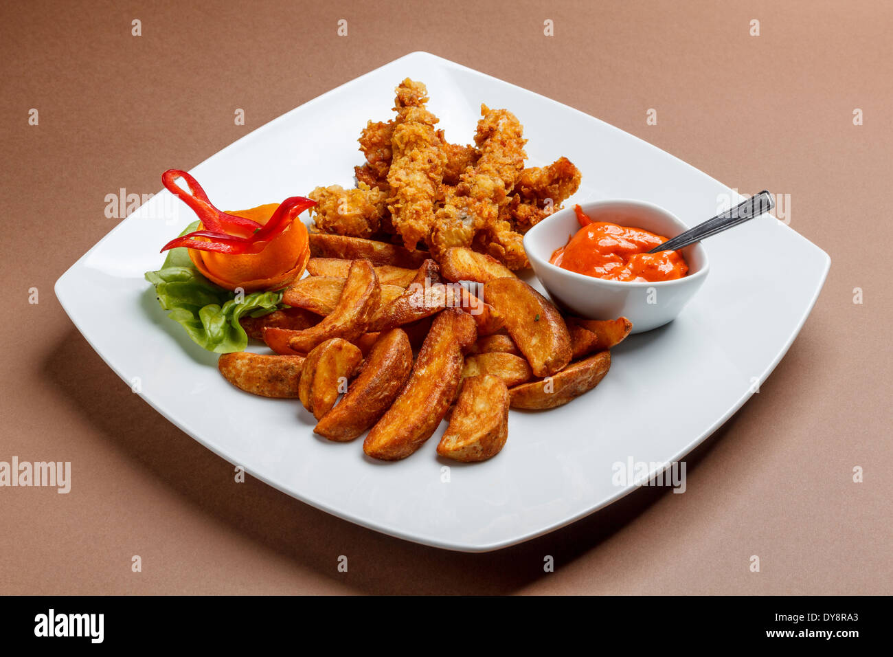 Pollo croccante strisce con spicchi di patate Foto Stock